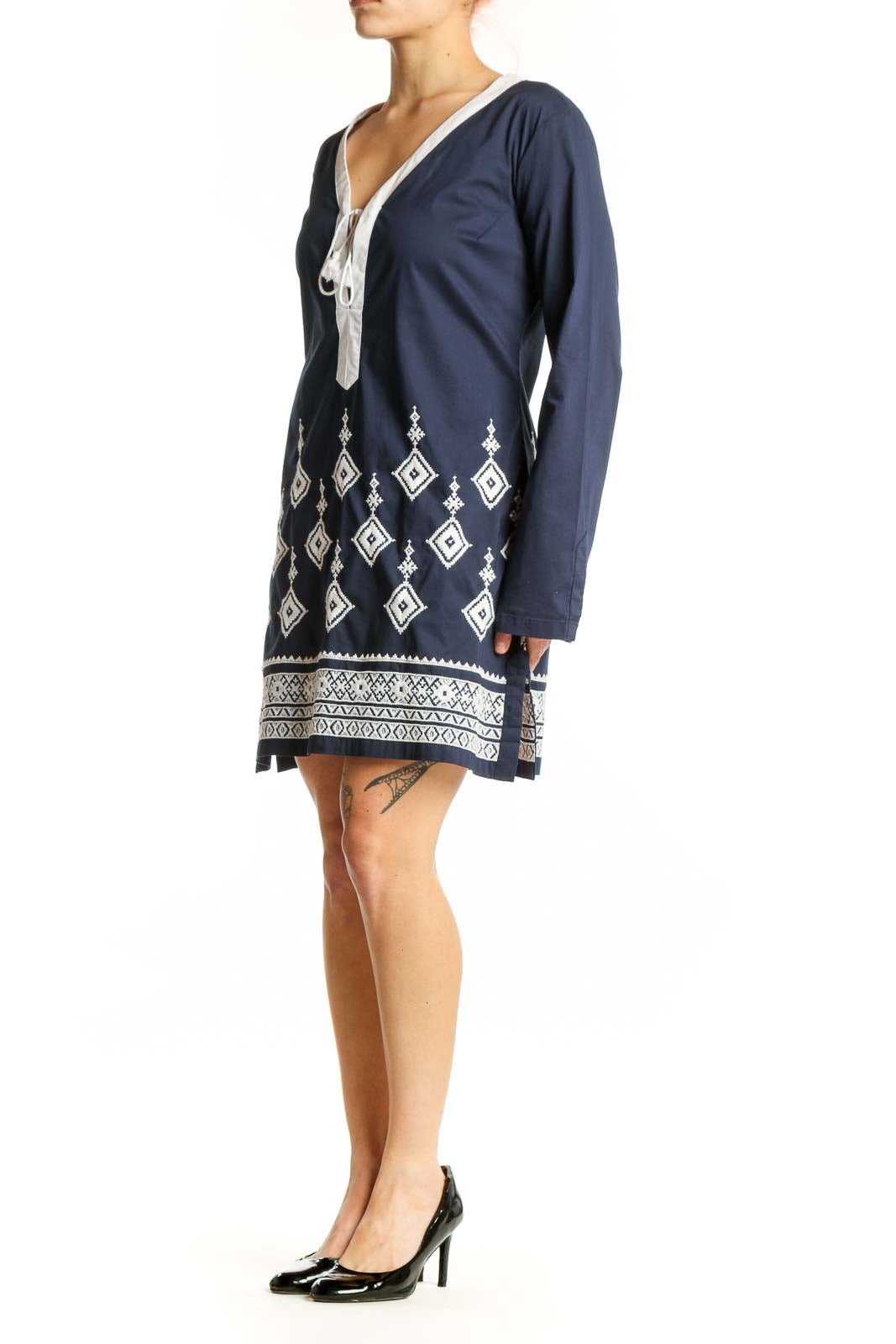 Navy geometric embroidered tunic dress with white tie V-neckline and diamond pattern details