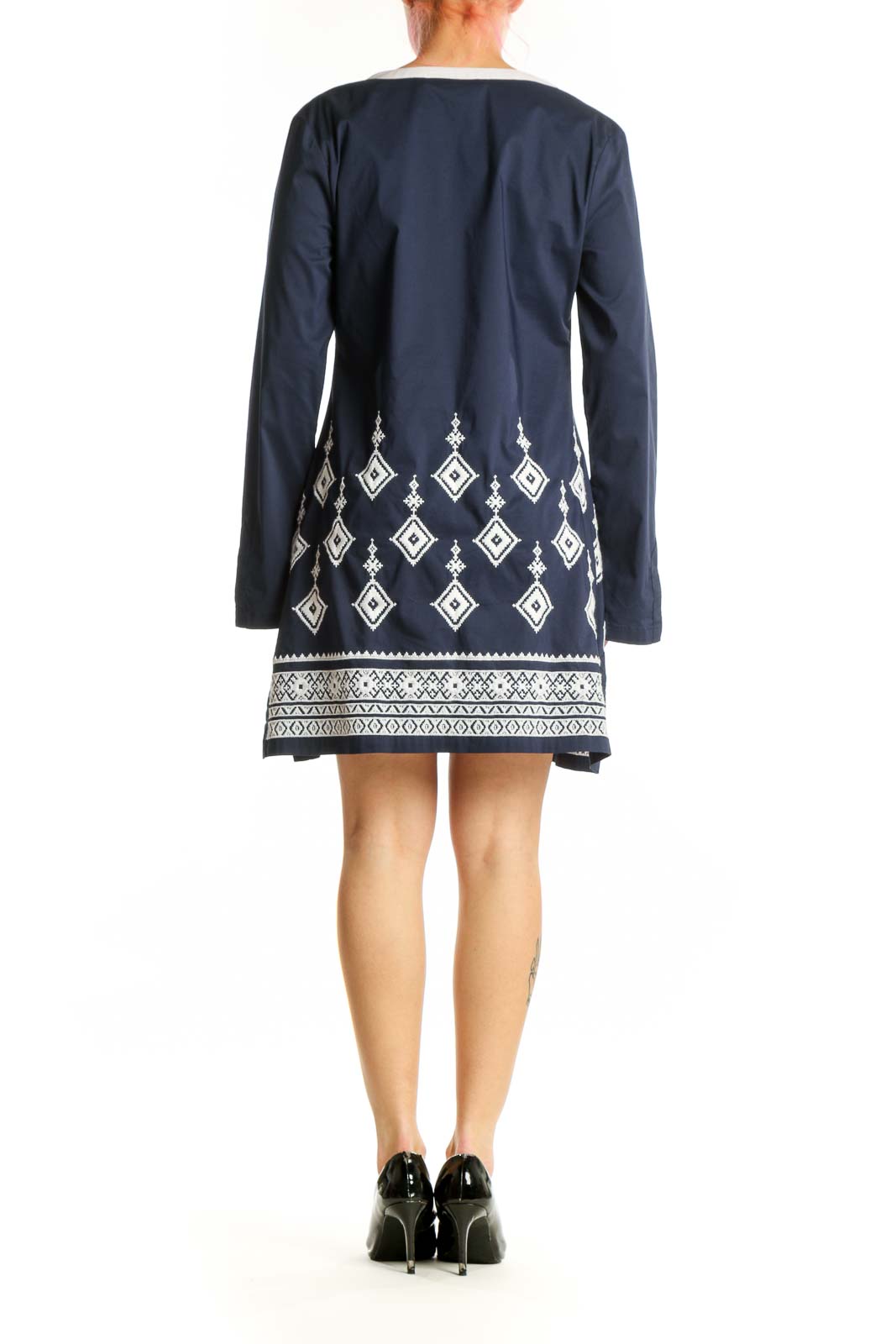 Back view of navy tunic dress showing geometric embroidery and flowing A-line silhouette