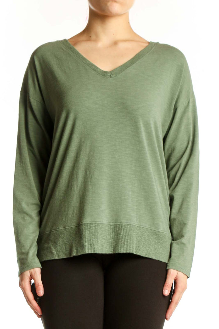 Green V-neck long sleeve top with relaxed fit, front view on model