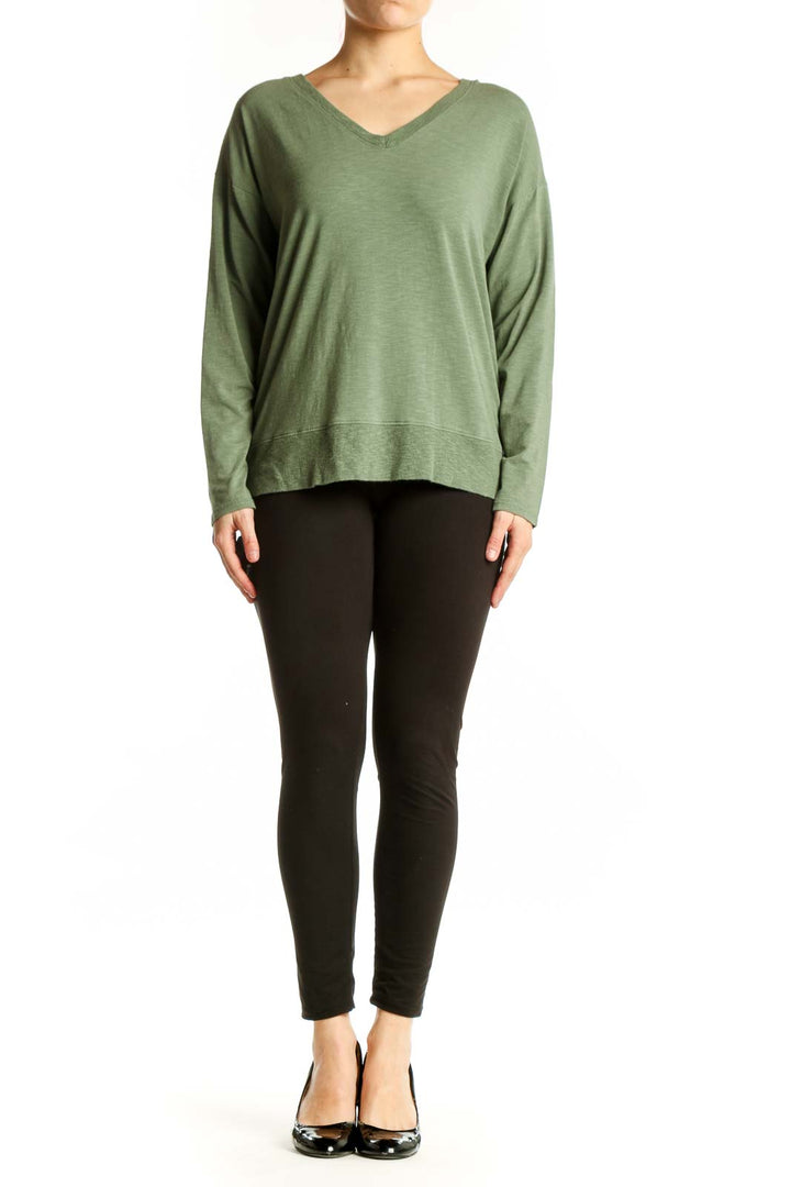 Green V-neck long sleeve top with relaxed fit, front view on model