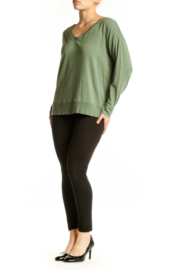 Green V-neck long sleeve top with relaxed fit, front view on model
