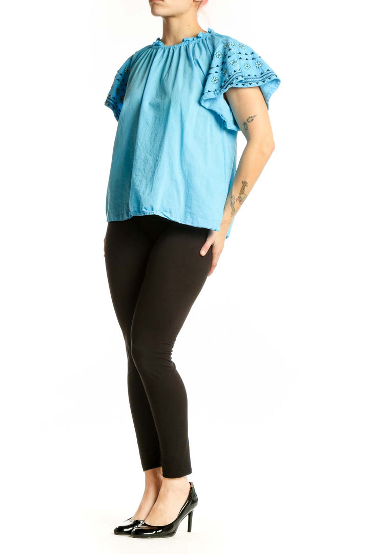 Blue cotton top with ruffled lace sleeves and gathered neckline, front view