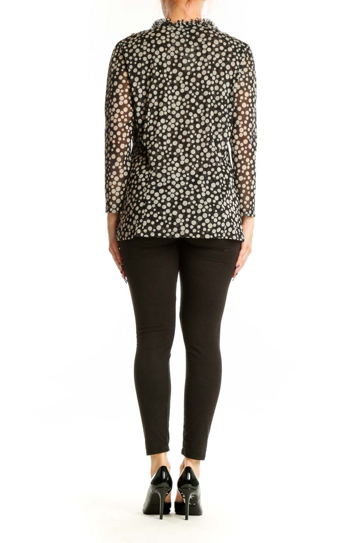 Black and white polka dot blouse with ruffle V-neckline and long sleeves, back view