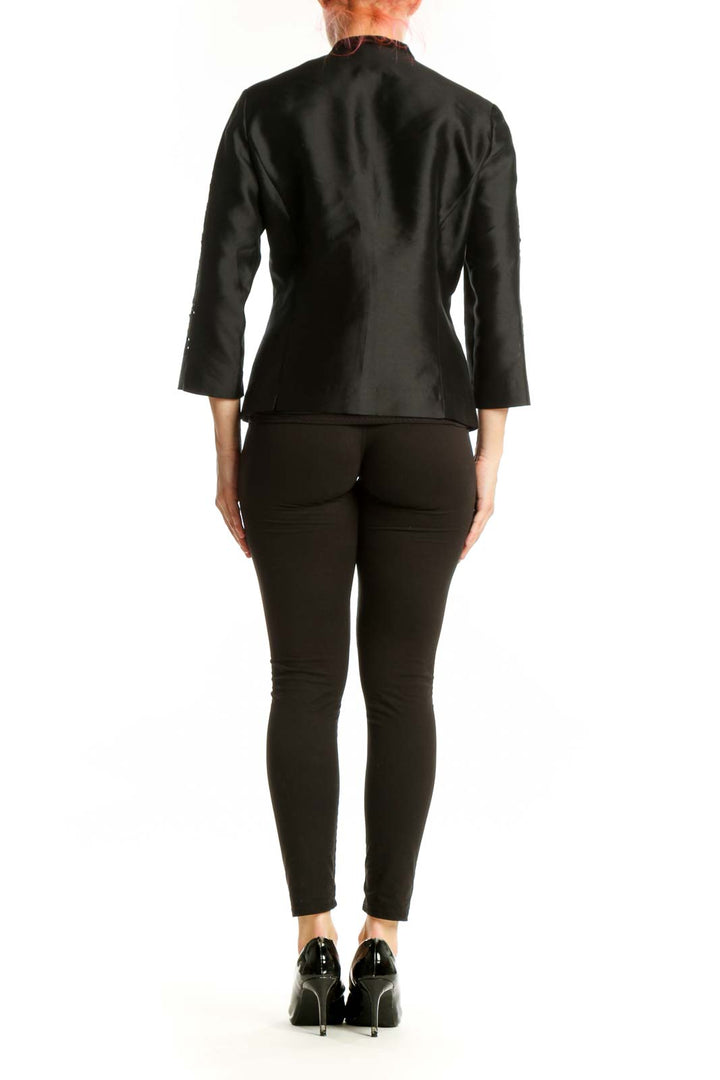 Black silk jacket back view showing beaded sleeve detailing and tailored fit