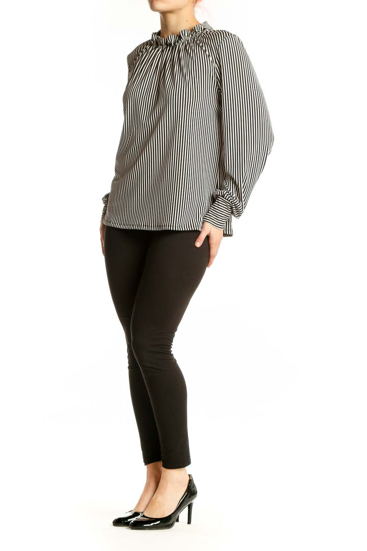 Black and white vertical striped blouse with gathered neckline and long voluminous sleeves