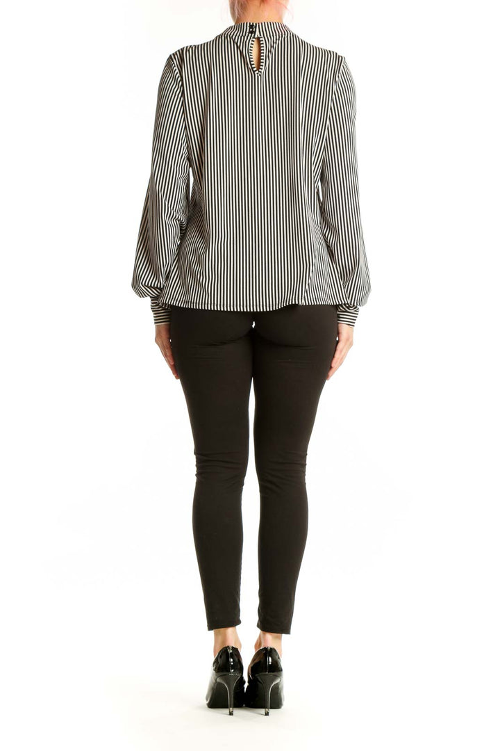Back view of black and white striped blouse showing gathered neckline and elasticated cuff details