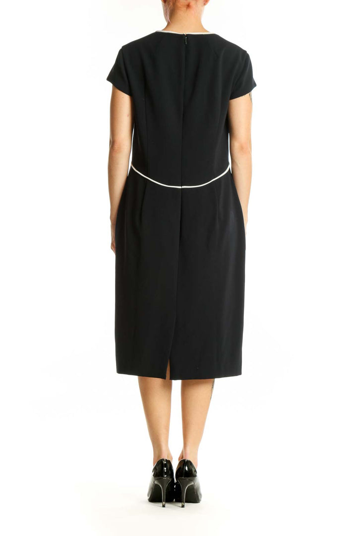 Black short sleeve A-line midi dress with white contrast waistline detail, back view