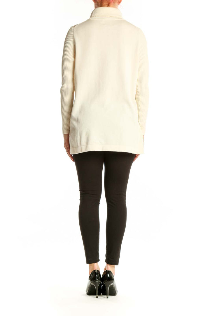 Back view of cream turtleneck knit sweater showing relaxed fit and ribbed sleeve detail