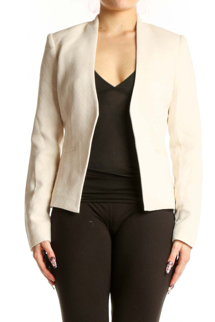 Front view of cream polyester blazer by Calvin Klein, XS size, featuring open-front tailored design and long sleeves