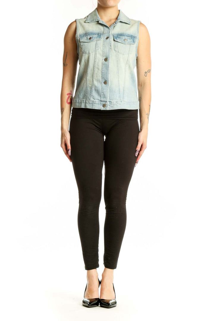 Light blue denim sleeveless vest with button-front closure and chest pockets, worn with black leggings