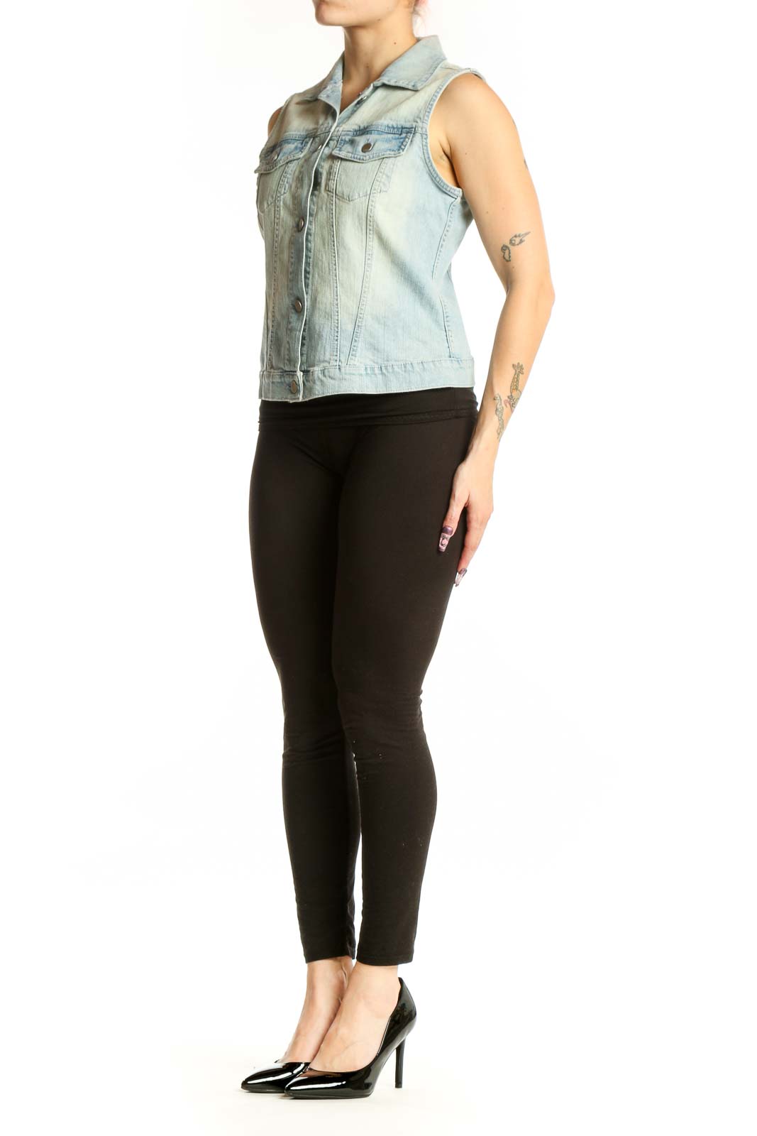 Light blue denim sleeveless vest with button-front closure and chest pockets, worn with black leggings