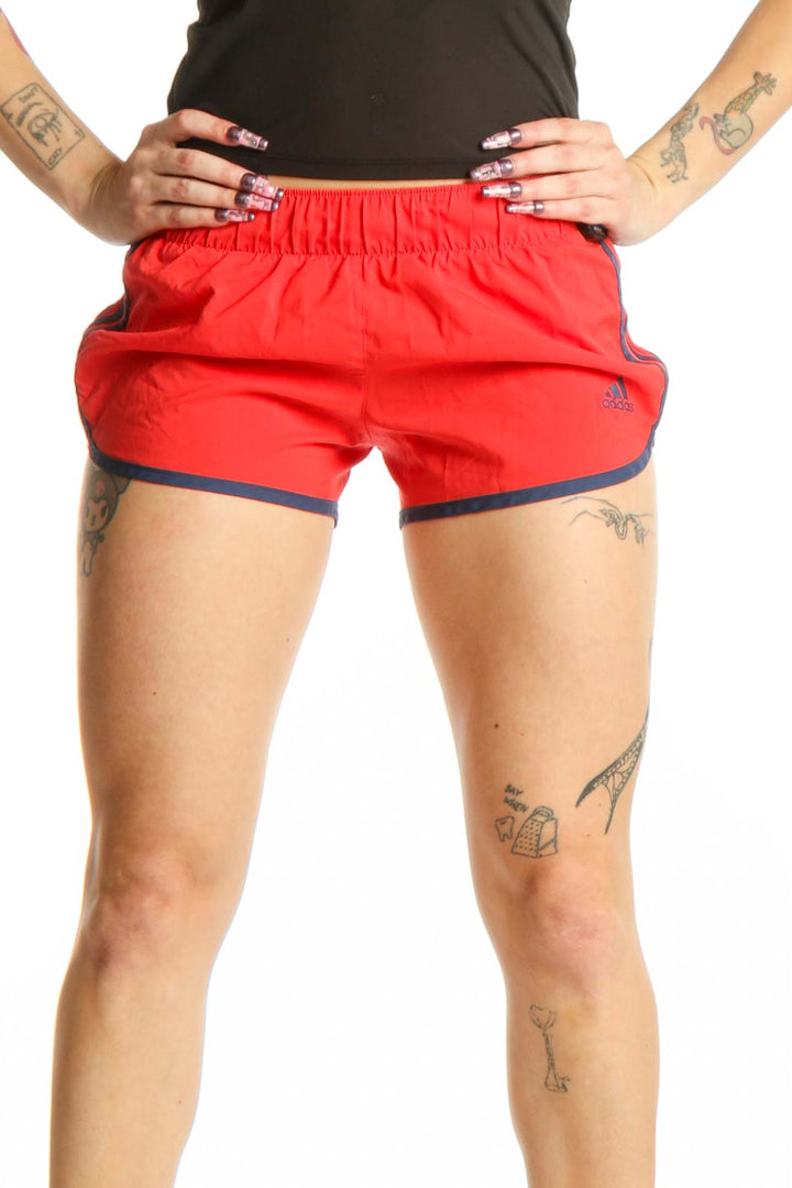 Red Adidas athletic shorts with navy trim, front view on model, XS size
