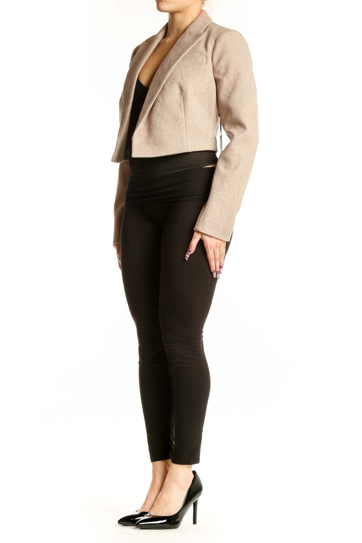 DKNY beige cropped blazer jacket with notch lapel worn over black top, front view