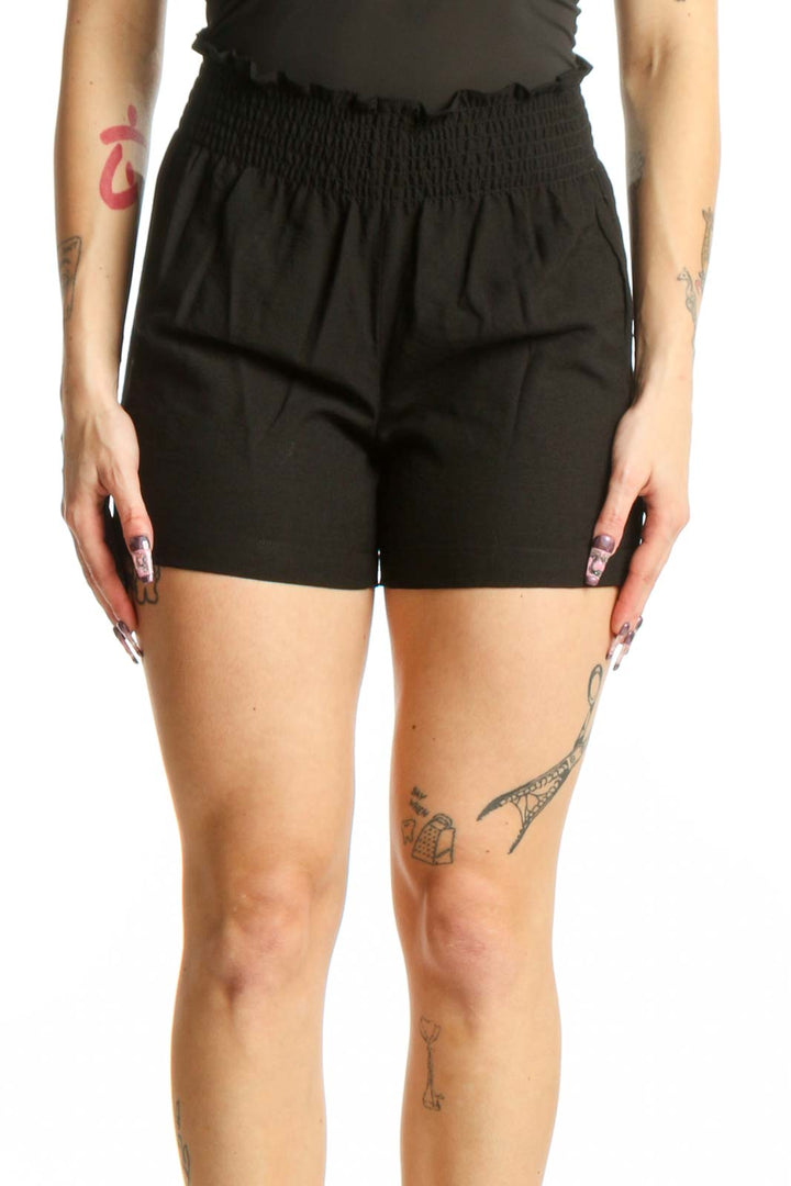 Black paperbag shorts with smocked waistband by Calvin Klein, front view on model