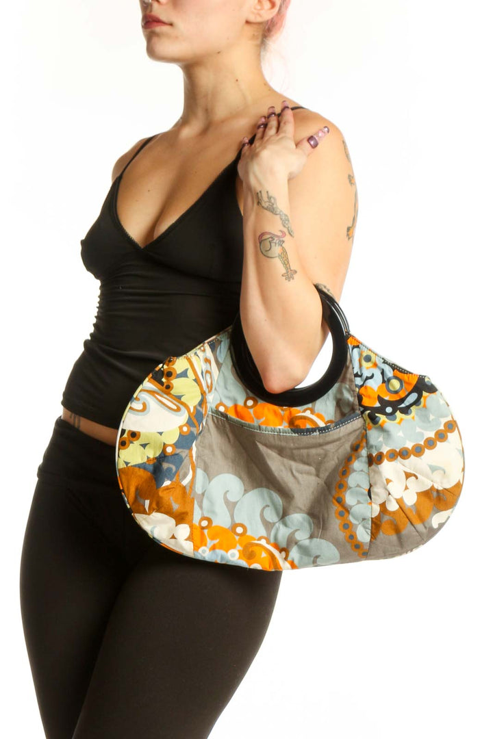 Multicolor floral cotton clutch by J.Crew with black handle, featuring vibrant orange, yellow, navy and cream ornamental print pattern