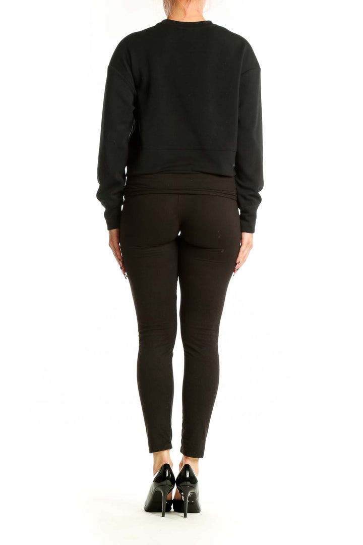 Back view of black crop sweatshirt showing back cutout design and cropped silhouette