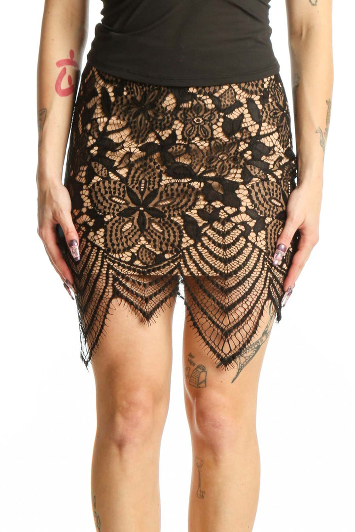 Black lace mini skirt with geometric and floral patterns and scalloped hemline, front view