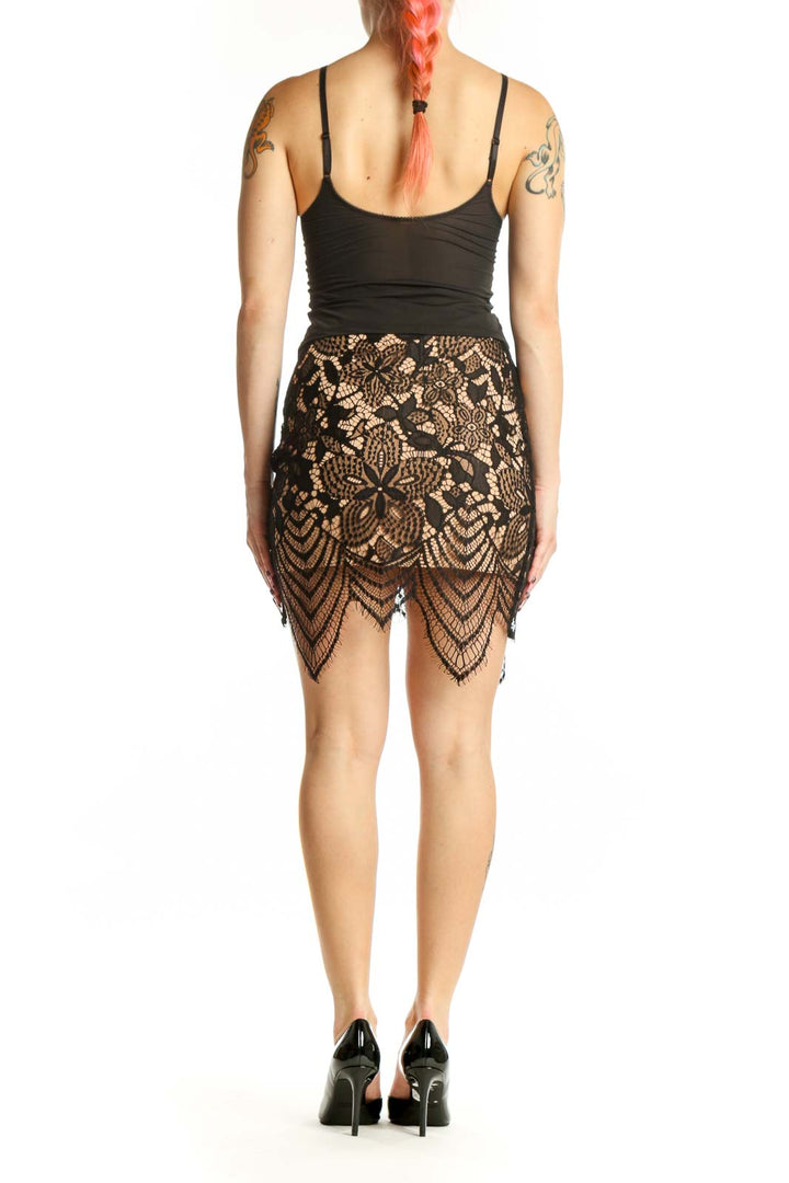 Black lace mini skirt with scalloped hem detail, back view on model