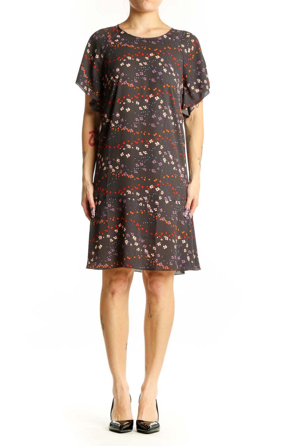 Black floral short sleeve Cabi dress with red, orange, and cream scattered blooms, front view on model