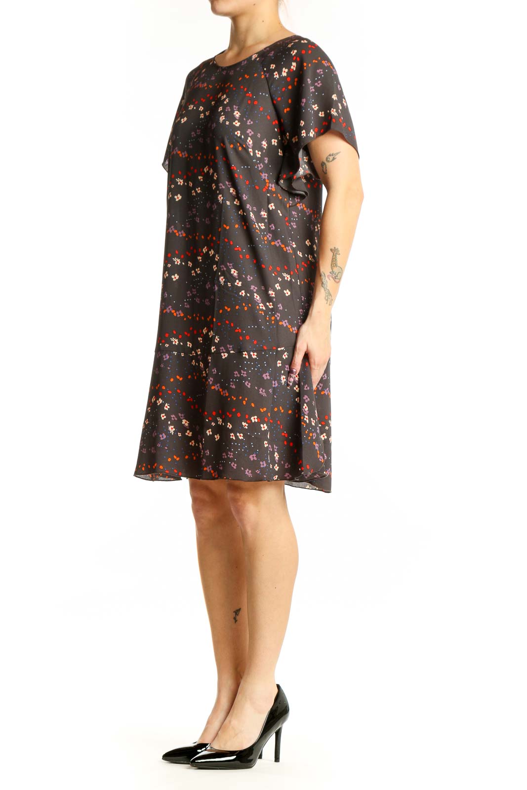 Black floral short sleeve Cabi dress with red, orange, and cream scattered blooms, front view on model
