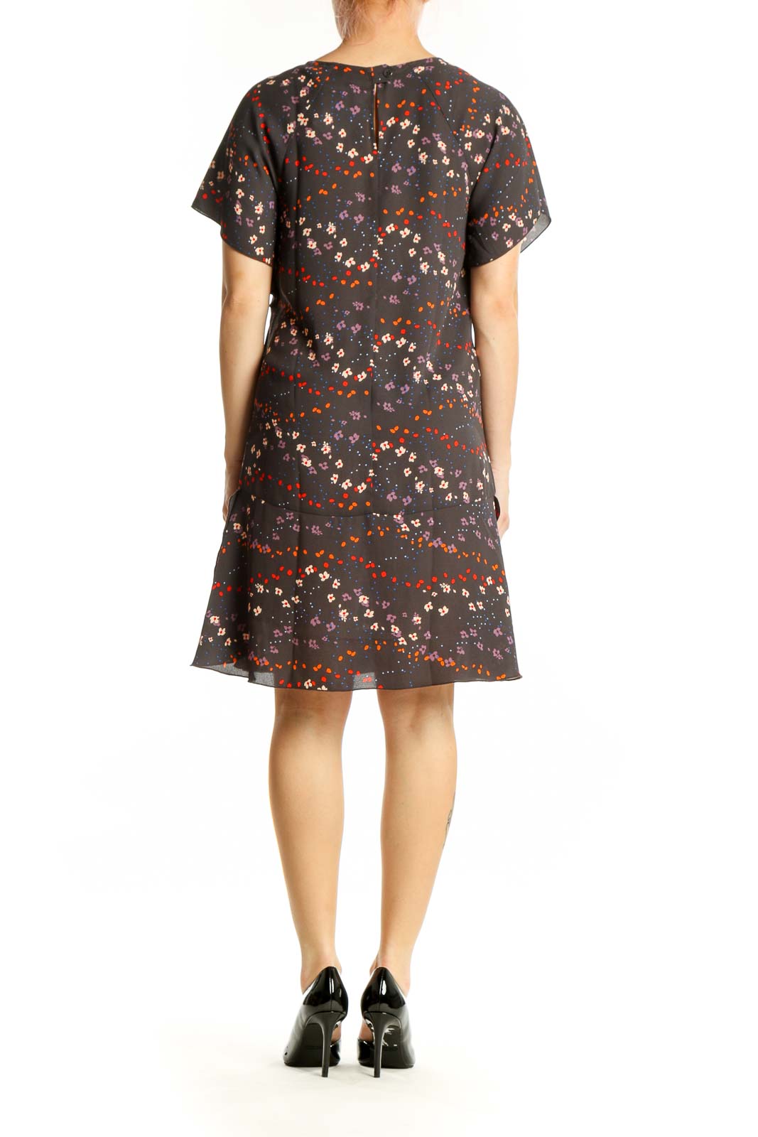 Black floral short sleeve Cabi dress with red, orange, and cream scattered blooms, back view on model