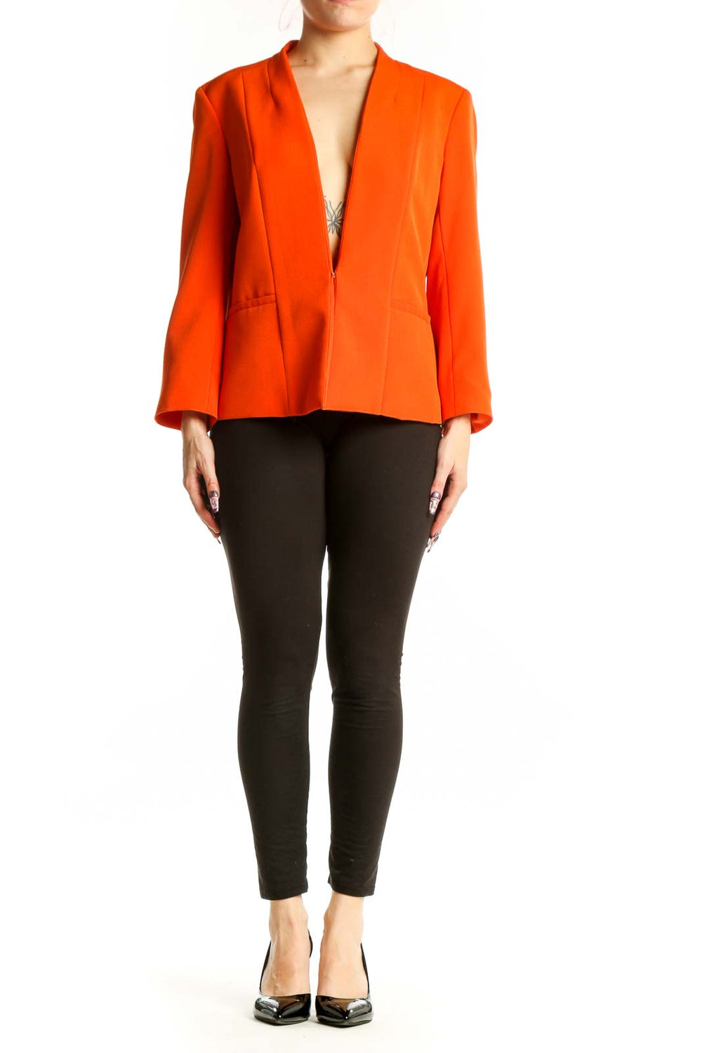 Orange blazer with peplum hem and long sleeves, front view on model wearing black pants