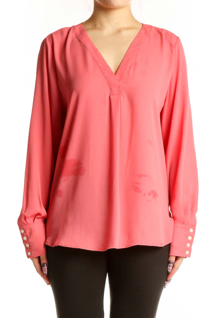 Coral pink V-neck long sleeve blouse by Ann Taylor with button cuff details, front view on model
