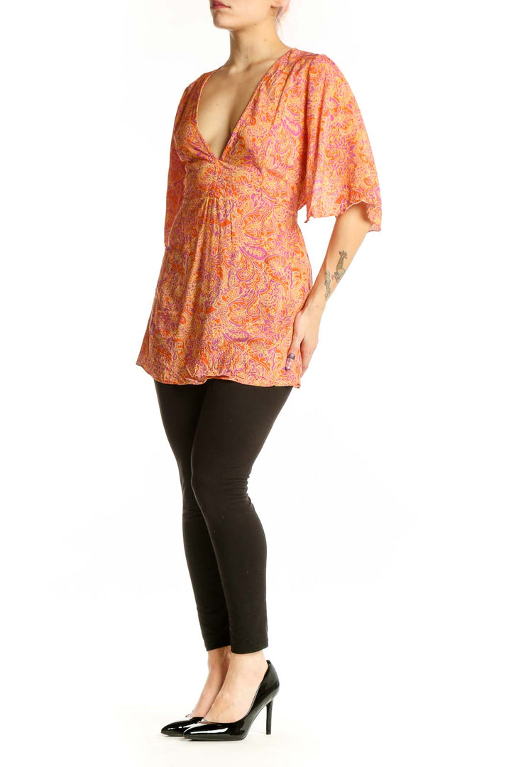 Orange and pink paisley print wrap top with V-neckline and three-quarter sleeves by VIX by Paula Hermanny