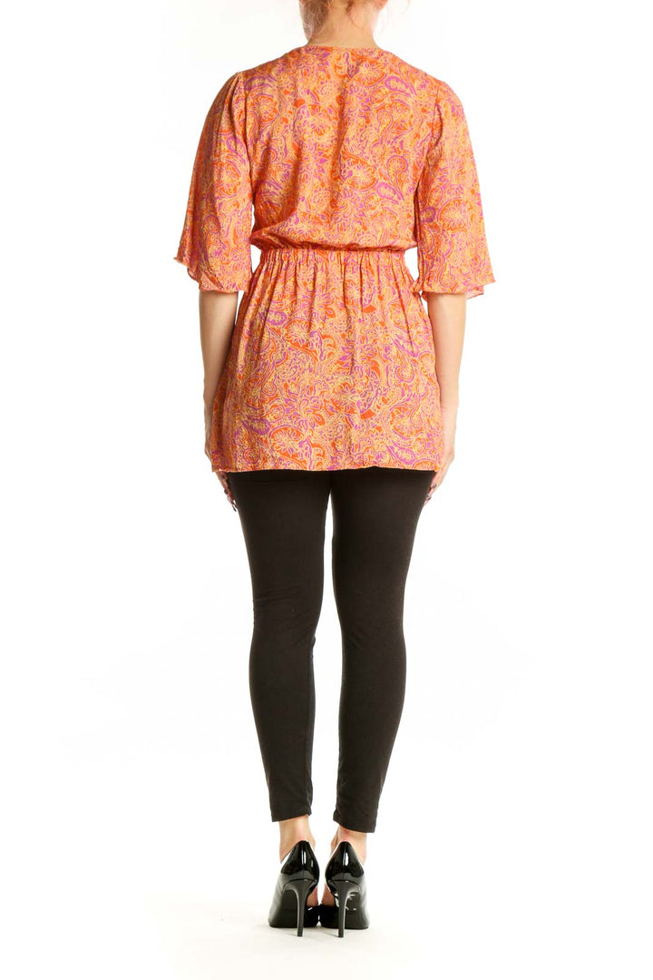 Back view of orange paisley print rayon wrap top showing fluid drape and wrap design