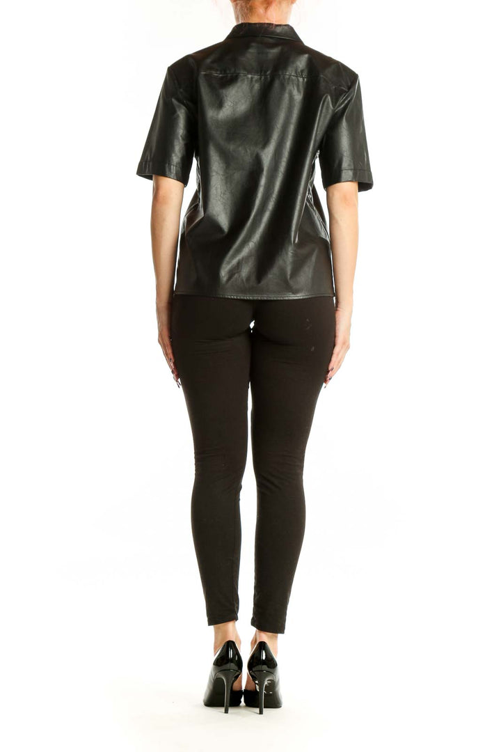 Black leather button-up short sleeve shirt, back view on model wearing black pants