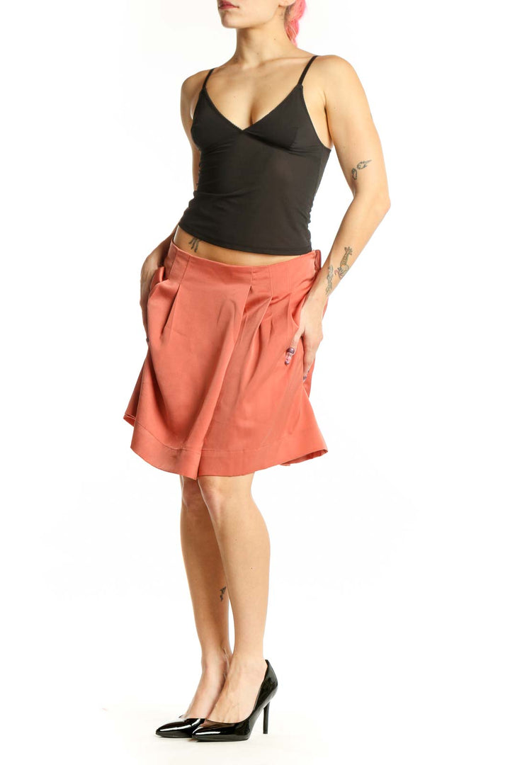 Coral pleated knee-length shorts from Banana Republic, front view showing waist pleating and solid color design