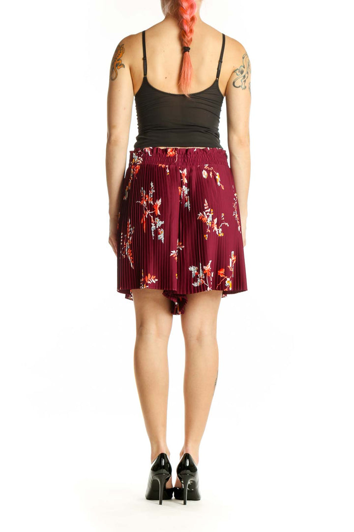 Back view of burgundy floral pleated shorts showing pleated design and flattering silhouette