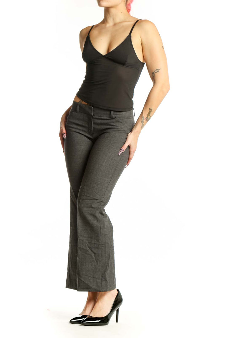 Front view of gray Theory dress pants with tailored flat-front design and mid-rise waist on model wearing black top