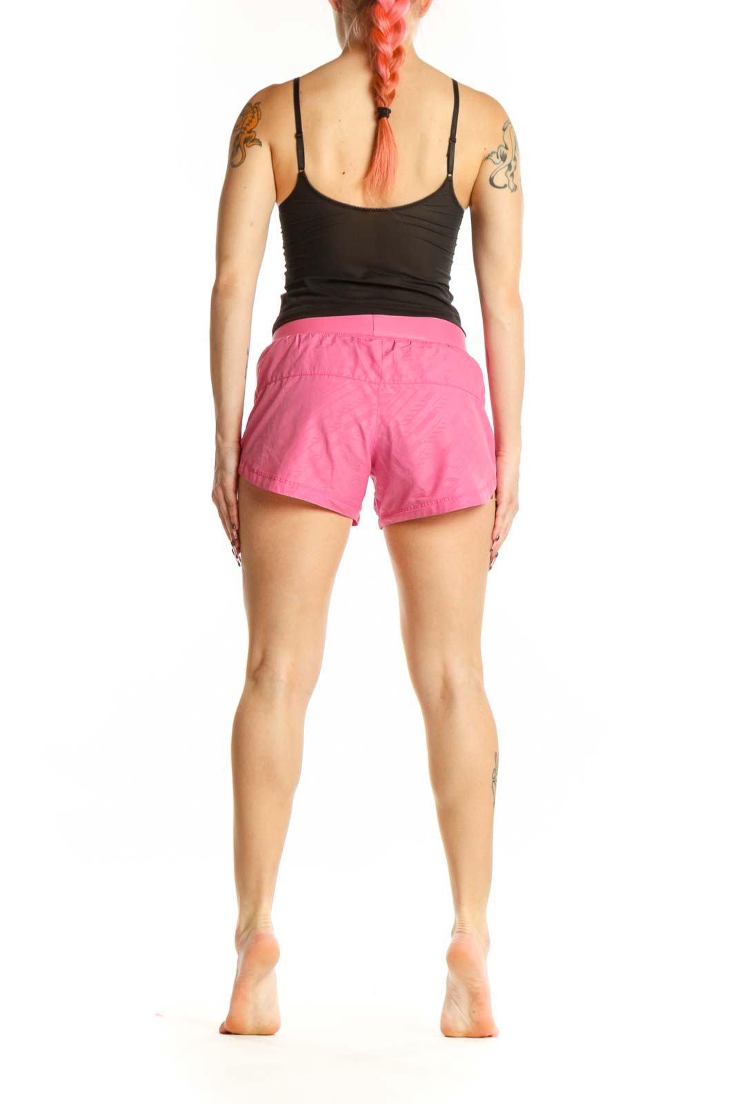 Back view of pink Nike athletic shorts showing fit and length on model