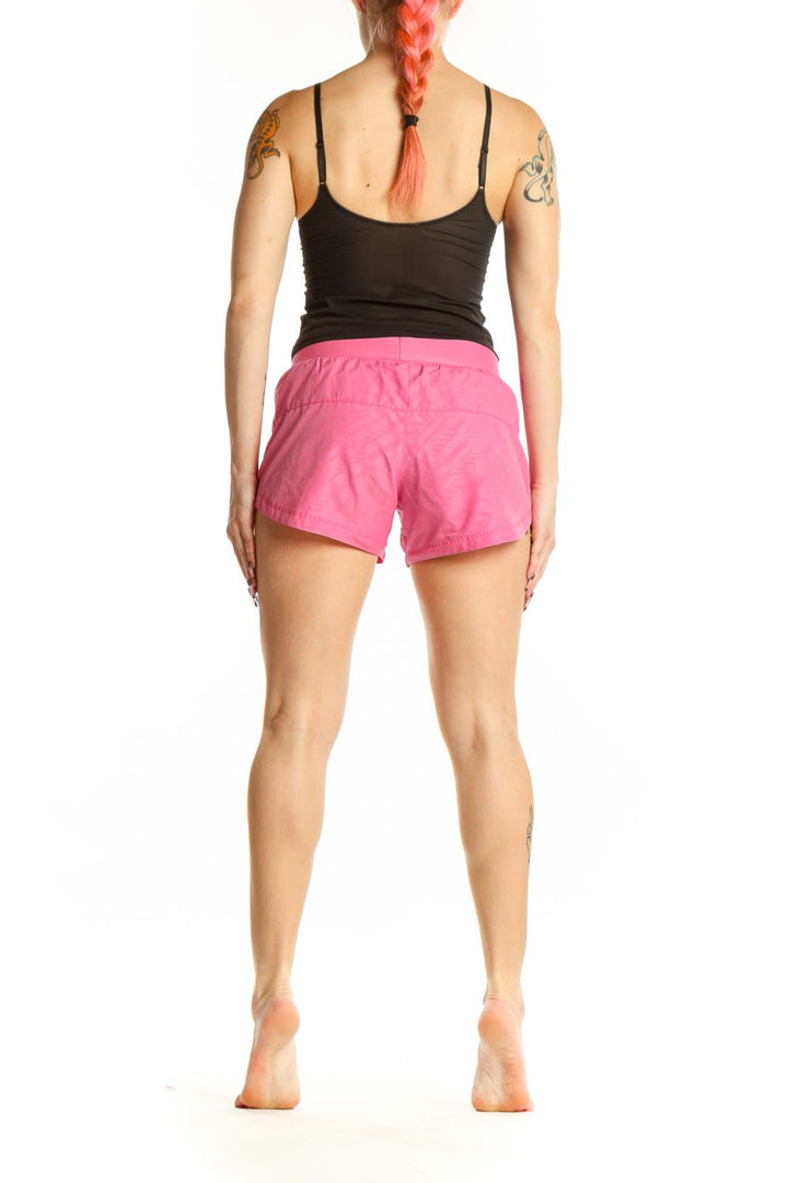Back view of pink Nike athletic shorts showing fit and length on model