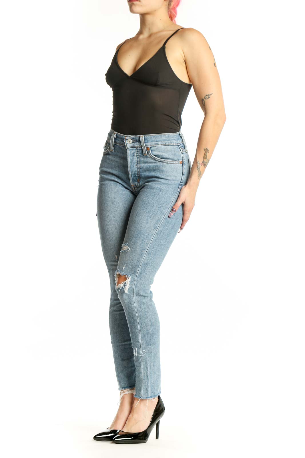 Light blue Levi's distressed skinny jeans front view, high-waisted with ripped thigh detailing, worn with black top