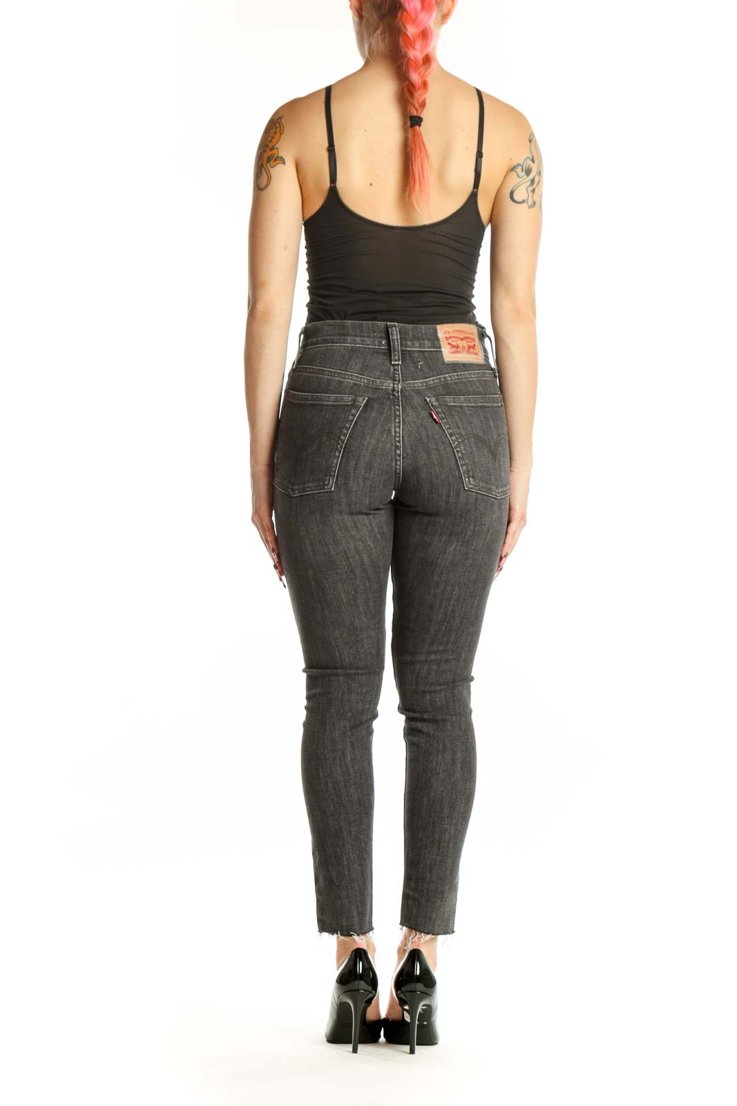 Side view of gray cropped skinny Levi's jeans showing fit and raw edge hem detail