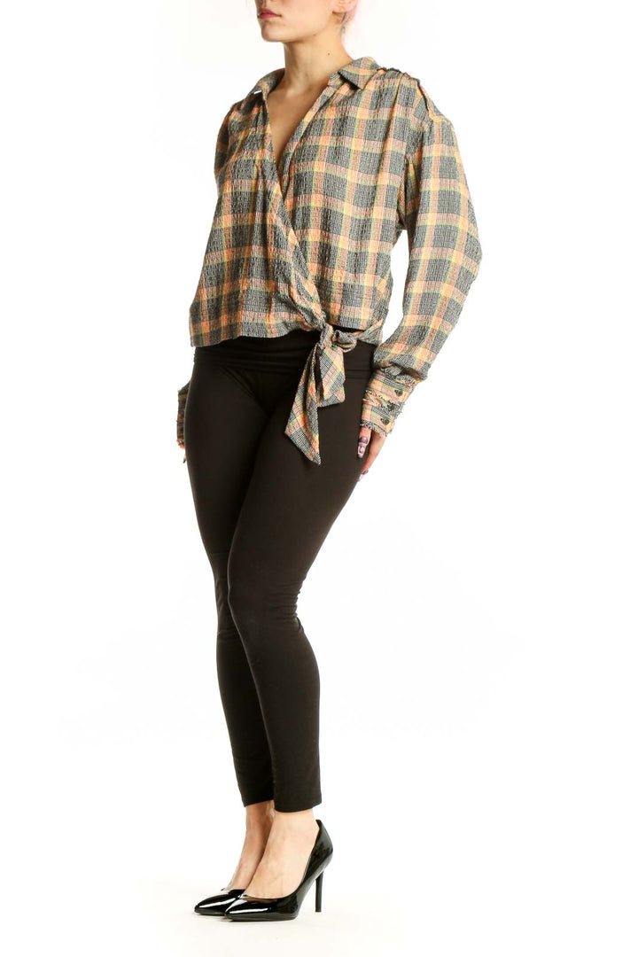 Multicolor plaid tie-front button-up shirt with long sleeves and tie-front detail at hem, worn with black leggings