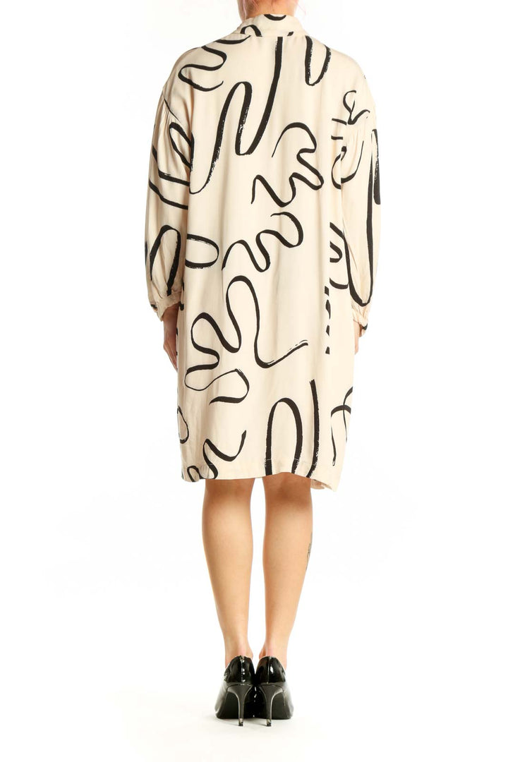 Back view of cream abstract line print shift dress showing relaxed silhouette and knee-length cut