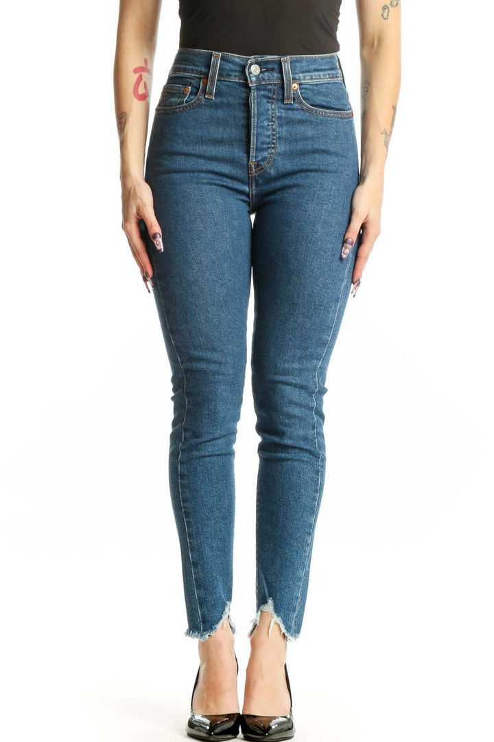 Front view of blue Levi's skinny jeans with high-waisted fit and distressed raw hem on XS model
