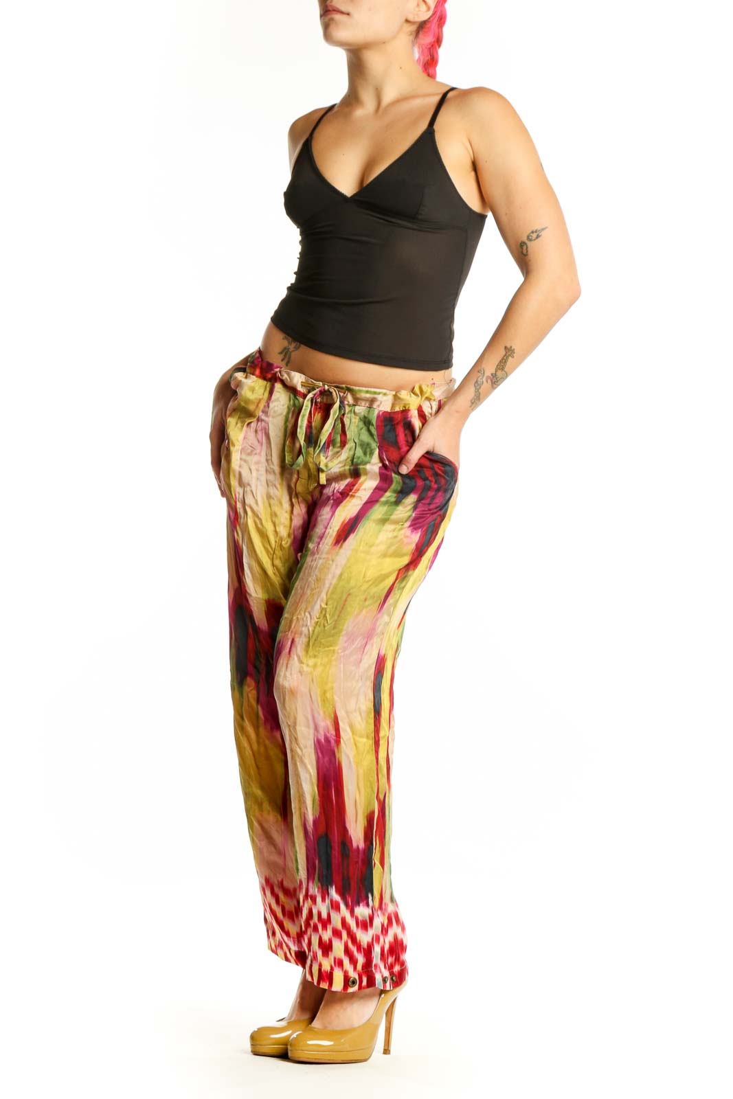 Front view of multicolor silk ikat print pants with vibrant red, yellow, pink, and green watercolor pattern and geometric hem detail