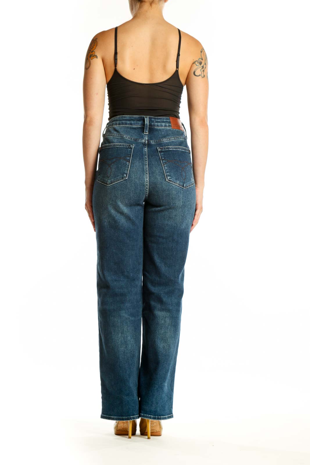 Back view of blue distressed denim jeans showing classic five-pocket design and knee rip details