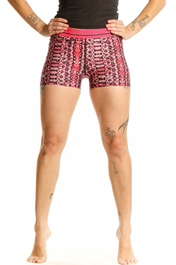 Front view of pink geometric print Under Armour athletic shorts with pink waistband on model