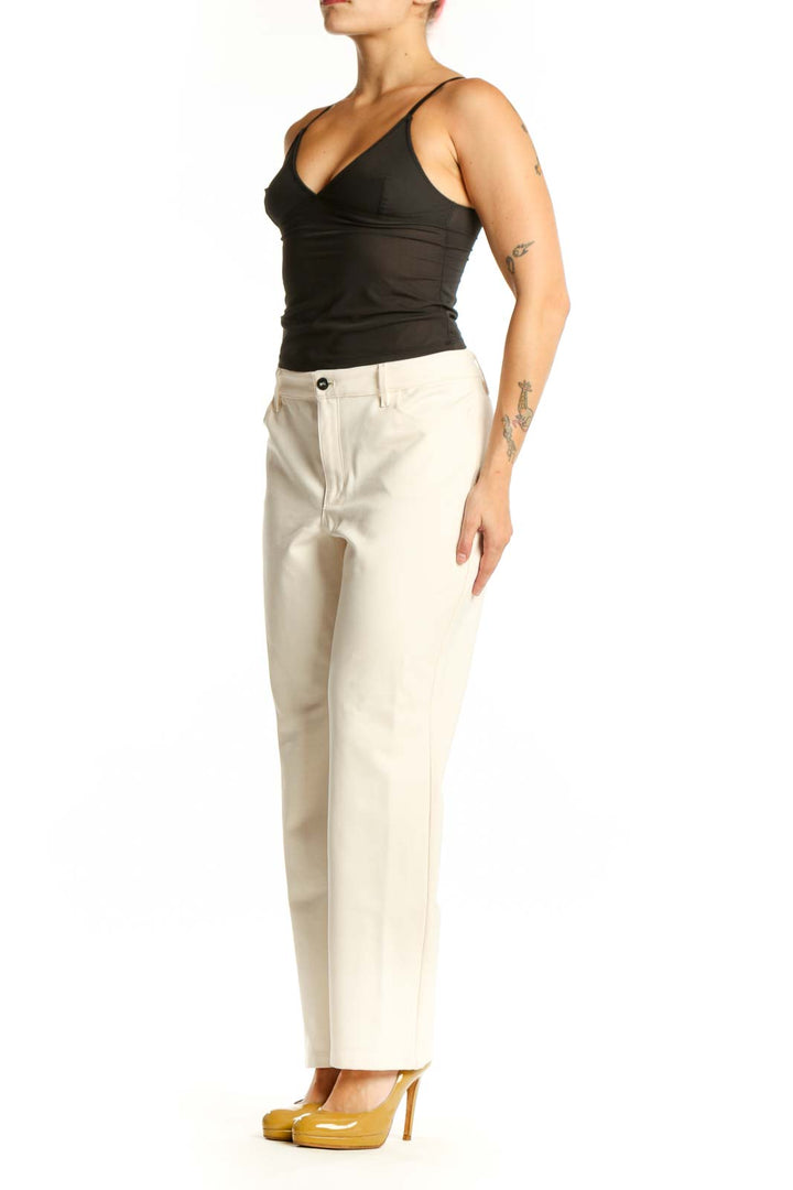 Front view of cream dress pants with straight-leg silhouette and high-waisted fit