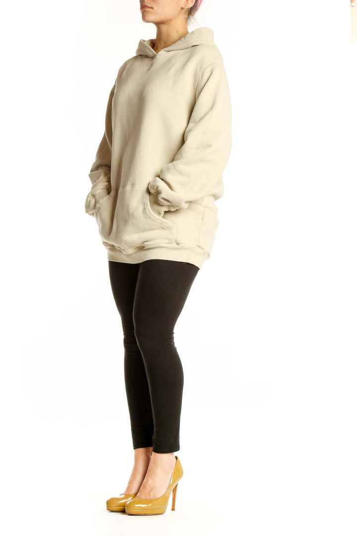 Woman wearing cream organic cotton hoodie with front pockets and relaxed fit by MB by Malene Birger