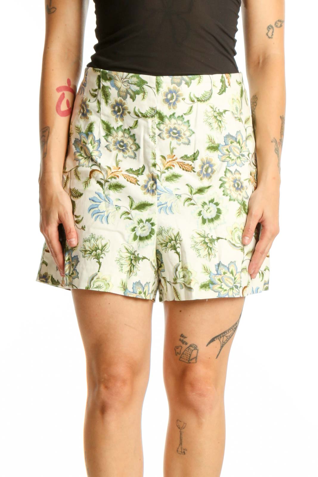 Front view of cream floral print LOFT shorts with green and blue botanical design, paired with black top