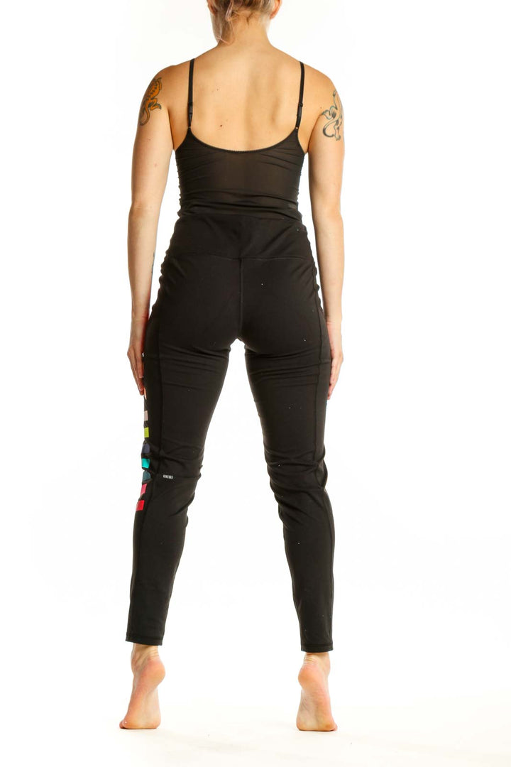 Black activewear leggings with vibrant neon colorblock design, back view showing full stripe pattern