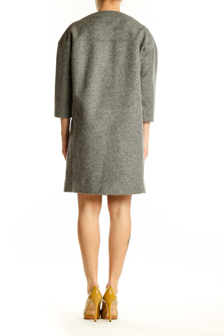 Back view of gray wool-blend shift dress showing relaxed silhouette and side pocket detail