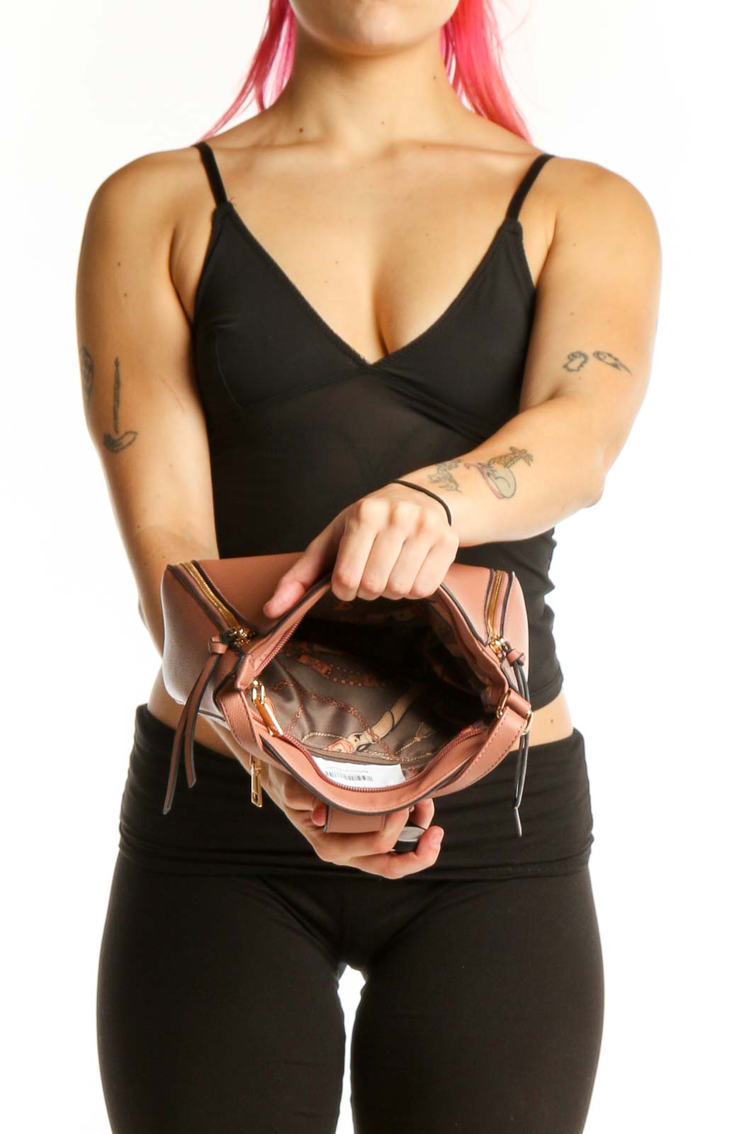 Back view of tan SilkRoll crossbody bag worn across body showing padlock closure and side zip details