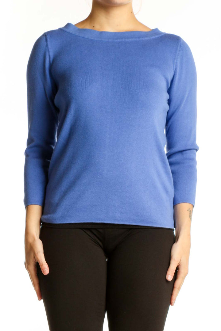 Blue crew neck top with three-quarter sleeves worn with black pants, front view
